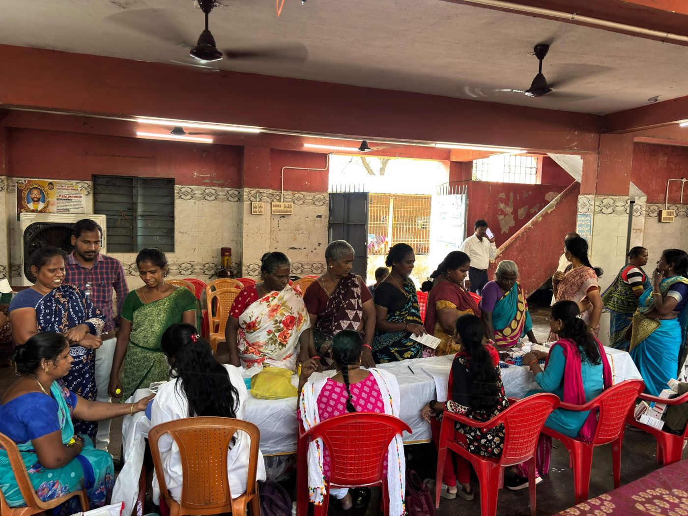 Community members gathered at tables during a health camp